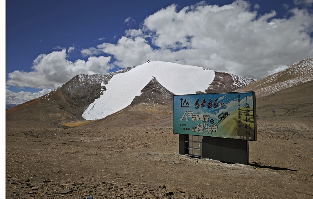 The north face of Rimazu (6,180m) seen from the 5,830m Laqiong La, the latter often cited as the highest motorable pass in China. The August 2025 route climbed to the apex of the rocky triangle in the center of the face, then directly up snow to the summit. Descent was along the right skyline ridge.  