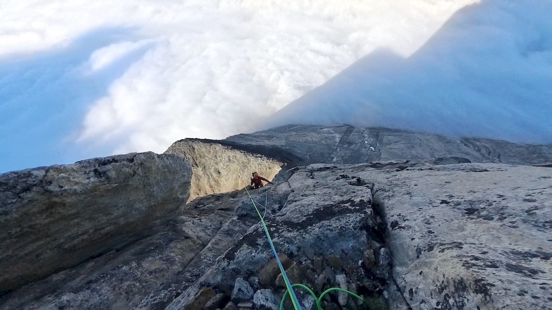 Above a sea of fog, Marco Dattolo seconds the final pitch on the pillar (6a) on the southwest side of Titan II.