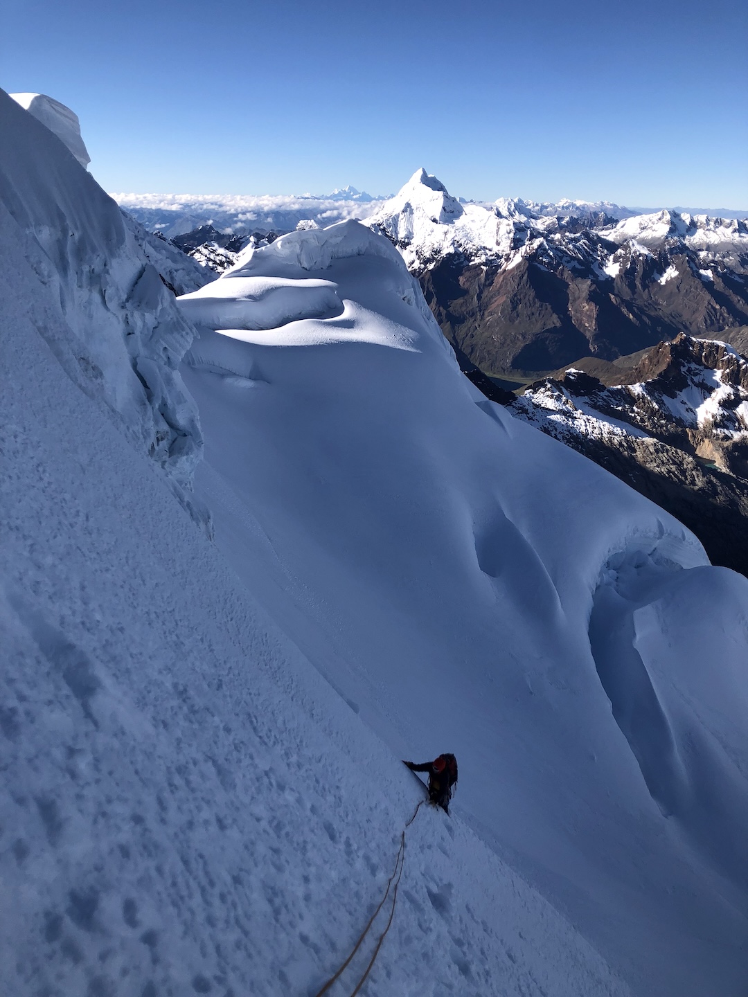 Matt Stacy simul-climbing the south face of Palcaraju with the formidable Nevado Huatsán in the background.