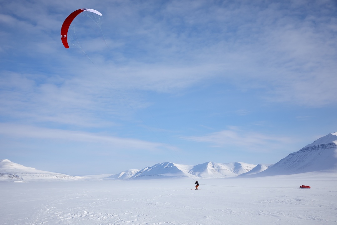 Sasha Doyle flying across Sassendalen with her snowkite and pulks in tow.