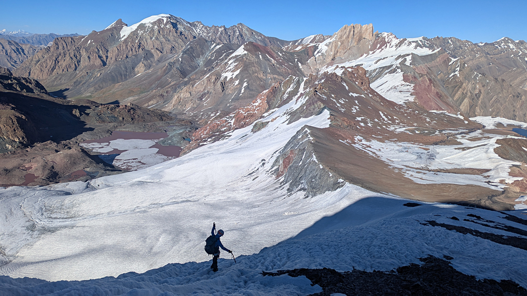 Descending from twin-summited Peak 5,615m, with the red lake of Tso Marpo below, base camp off picture to the left, and the big peak of Machu Kangri (6,086m) in the background. 