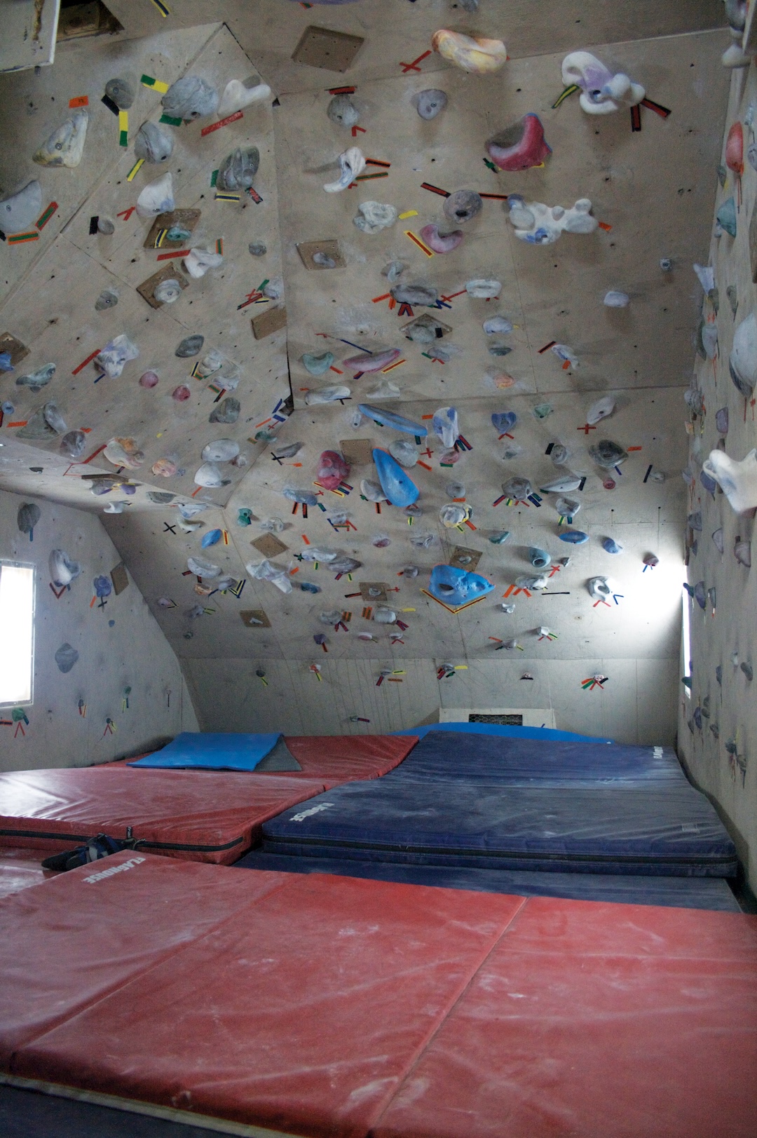 Here we see a home gym mat configuration with plenty of gaps that could cause ankle injuries. While padding for a garage climbing wall is a personal choice, commercial gyms should provide gap-free coverage to prevent ankle injuries. For their part, indoor climbers should stay alert for potential hazards at the gym to avoid and/or report them. Eli Duke—Wikimedia